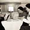 Shirley Temple and teacher Frances Klamt being observed by Better Homes and Gardens writer, Gladys Denny Shultz, in Shirley's dressing room trailer during filming of Just Around The Corner, 1938